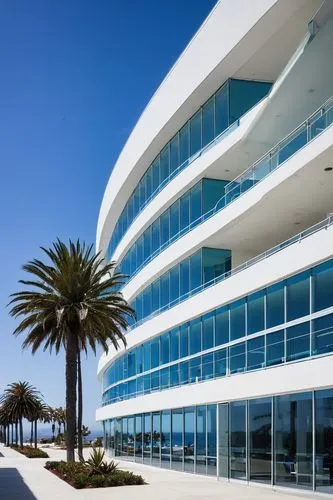 Santa Monica commercial building, modern licensed architectural design, glass facade, steel frames, sleek lines, minimalist decor, floor-to-ceiling windows, ocean view, beachside location, palm trees 