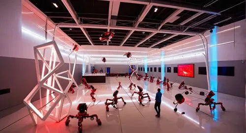 In a vast space, the bright red arena is filled with ominous spectators. The spheres are glowing, and circuits are stacked with wires spinning in the air beneath their feet. A pair of robotic athletes