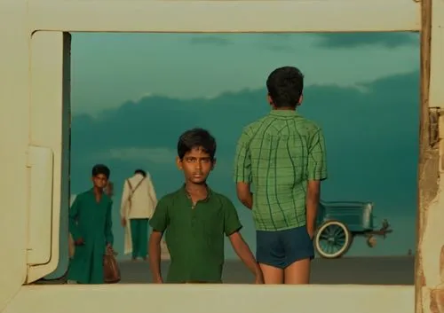 Neel Kamal watches from far wearing a dark green coat a thief boy is puting his hands on a man's pocket. Rikshaw pullers pull their rikshaw on the road in 1940s Madras Presidency early morning,swades,