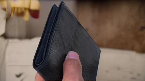 person with their hand on an item by the fireplace,wallet,wallets,cardholder,rupees,noteholders,pocket flap