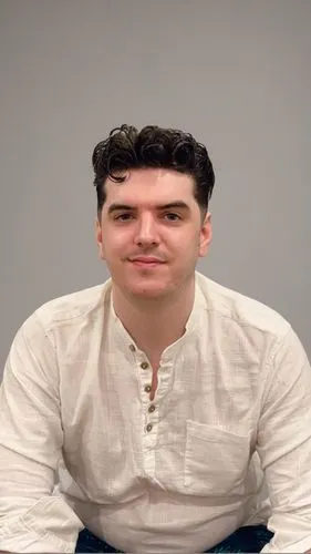 a man sitting at a table in front of a laptop,peterel,martyn,finkleman,defranco,greek in a circle,painewebber,Pure Color,Pure Color,Light Gray