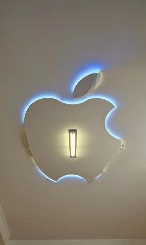 Gypsum decoration in the ceiling of a room with hidden LED lighting,an apple symbol with glowing lights in a room,ceiling light,ceiling lamp,wall lamp,apple logo,ceiling lighting,apple desk,Photograph