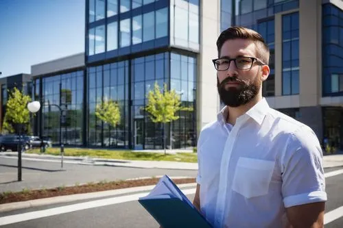 Modern architectural designer, male, 30s, standing, confident pose, glasses, short brown hair, beard, white shirt, dark blue trousers, holding a large portfolio, Bellingham WA, contemporary office bui