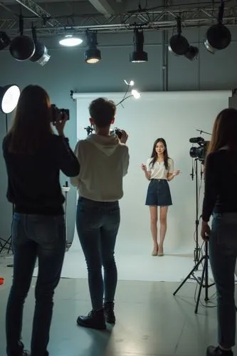 In the studio, multiple people are located in the center of the frame, with the model and cameraman at a distance of 5 meters. A Chinese female cameraman raised her camera and took a full body photo o