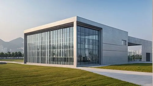 a large glass building in a park setting,glass facade,epfl,phototherapeutics,snohetta,voestalpine,new building,shenzhen vocational college,glass building,siza,modern building,structural glass,solar ce