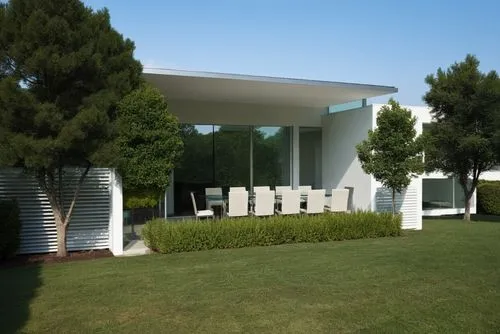 VISTA DE DIA ,MANTENER VOLUMETRIA Y FORMAS GRAN CANTIDAD DE VEGETACION  ,PRIMER PLANO PASTO EN PISO,a white room with chairs sitting outside of it,landscape design sydney,3d rendering,landscape design