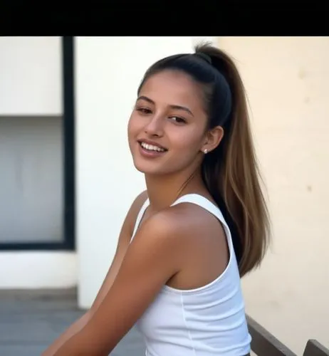 The Moroccan girl is sitting on a bench in the street in Tel Aviv.  Her hair is pulled into a high, tight ponytail.  She wears a short skirt and a white tank top.  At her feet, sneakers.  she is smili