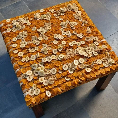 Utilize dried and treated orange peels to create a sturdy ottoman frame, then weave strips of banana peel or coconut husk for a natural and eco-friendly seating surface.,coffee table,honeycomb stone,f