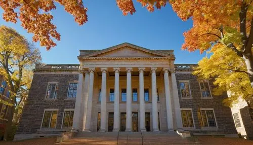 Yale University School of Architecture, prestigious building, historic columns, grand staircase, large windows, stone walls, mature trees, autumn leaves, sunny day, blue sky, low-angle shot, 3/4 compo