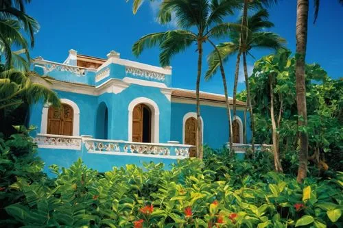 stucco walls, wooden accents, tropical trees, blue sky, soft focus background.,a very pretty blue building in the jungle,palmilla,hacienda,chucun,tropical house,palapa,aracataca,guadelupe,holiday vill