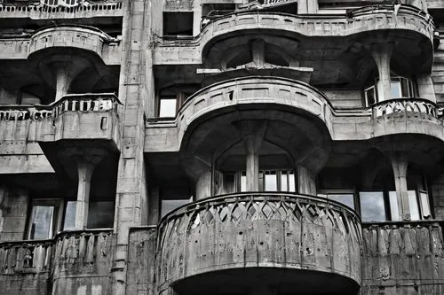 Brutalist Yugoslavian building, concrete structure, rugged texture, geometric shapes, fortress-like façade, narrow windows, bold angles, monumental scale, urban setting, Belgrade or Sarajevo cityscape