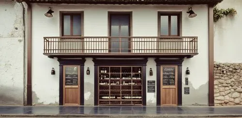 - Winebar embaixo com toldos retrateis listrados azul e branco.

,an entrance of a large building that has bottles in it,house facade,casa fuster hotel,porticos,house front,house entrance,casita,Photo