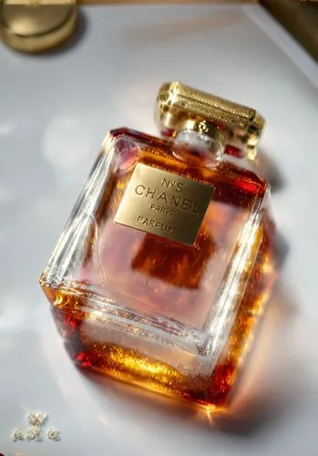 a vibrant glass and gold metal perfume bottle, each intricately designed in red and gold, sits in the center of a white room. The bottle's label is a deep amber color, and the label is adorned with in