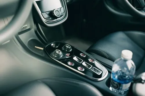 The interior of a car contains a bottle of water/4K resolution/documentary photography/natural light/master level works/ultra-high resolution/close-up shots,there is a control on in the car,gearshift,