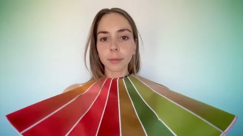 a woman holding up an assortment of color swatches,color fan,paper umbrella,colorama,hexahedron,winebow,jogbra