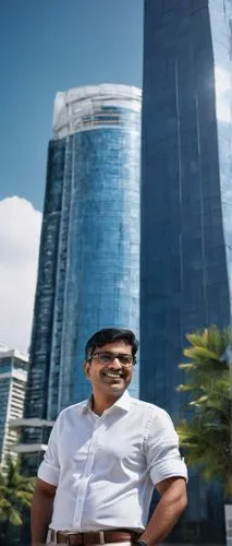 Middle-aged male architect, Chennai, India, standing in front of a modern skyscraper, hands behind back, confident smile, rectangular glasses, short black hair, formal wear, white shirt, dark blue tro