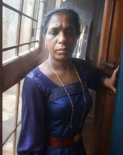 a woman standing in front of a window and looking through a glass door,shailaja,sivakami,abhinaya,manjeri,koyilandy,kaviyoor