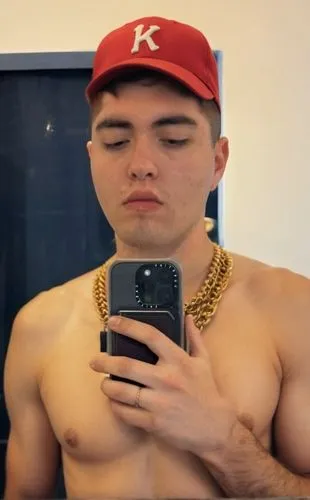 red baseball cap,a man looking down at his phone wearing a baseball hat,joji,vye,azn,malone,chaderton,rigondeaux