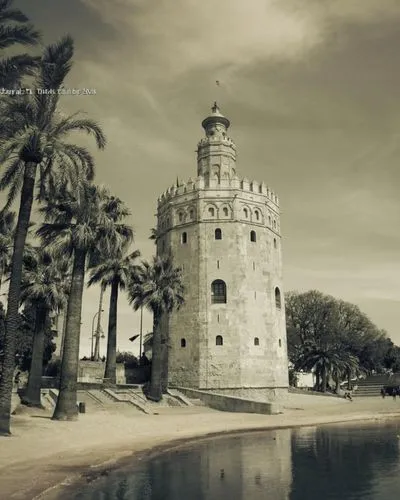 a white tower that is near water,sevilla tower,castillo,achilleion,cesar tower,tranquebar,hotel nacional