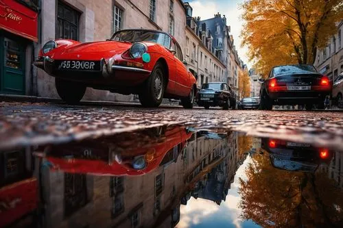 45-degree low-angle shot, cinematic composition, shallow depth of field, realistic reflections, HDR.,two cars parked on a city street with water reflecting it,reflexed,puddle,bordeaux,car wallpapers,p