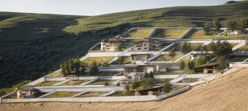 Small stone-cladded villas surrounded by stone-cladded boundary walls on a rural steep slope mountain with few trees with upper blue sky,terraces,terraced,eco-construction,building valley,bendemeer es