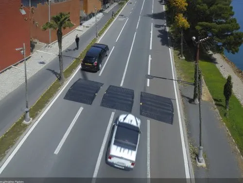 cojin reductor de velocidad hecho de plastico negro 

calle en concreto 

personas caminando a los lados de la calle en caminos de piedra 

,cojin reductor,street view,photogrammetric,bus lane,bicycle