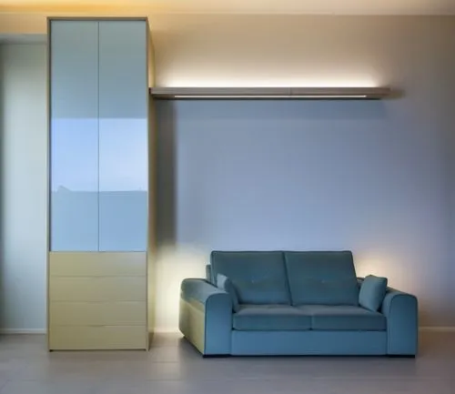 a large shelf above the sofa lights up with its large LED in a modern and warm style, the welcoming and soft sofa matches the rest of the house perfectly and the wardrobe next to it has a very well-ma