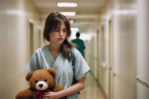 a young girl, suffering from colitis, slender figure, pale complexion, tired eyes, messy brown hair, worn-out expression, hospital gown, IV tube attached, walking slowly, holding a teddy bear, going b