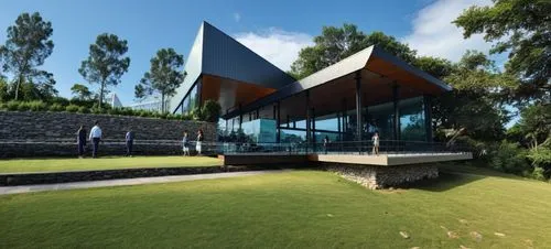 DISEÑO EXTERIOR DE UN COMEDOR  PARA UNA NAVE INDUSTRIAL, TERRAZAS CON MUROS DE PIEDRA, PERSONAS,CESPED, VENTANALES DE CRISTAL AMPLIOS, VISTAS PANORAMICAS, VEGETACION EXUBERANTE,a house with a big gras