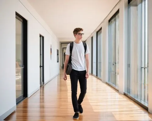 Young adult, male, solo, (22yo), short hair, glasses, white shirt, black pants, black shoes, backpack, holding a large portfolio, standing, Virginia Tech College, School of Architecture + Design build