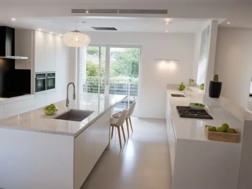 A kitchen design featuring only smooth, handleless cabinet fronts in pure white color. The cabinets have clean, modern lines, creating a minimalist and sleek aesthetic. The overall feel is one of orde