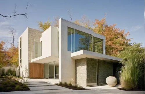 EXTERIOR DESIGN OF A MINIMALIST STYLE HOUSE, LOCATED IN A CORNER, WITH WALLS IN WHITE AND NEUTRAL COLORS, WITH A MAIN WALL WITH TRAVERTINE MARBLE COVERING, GLASS WINDOW IN THE CORNER, WOODEN DOORS, ER