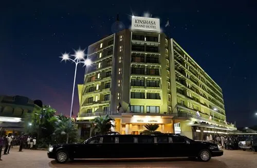 The hotel is in Africa. A one black limousine is parking in front of the hotel, where a huge crowd of African people is waiting outside. There is the press, there are photographers from African magazi