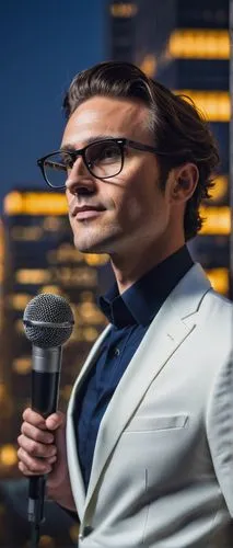 Modern architectural digest design show, 2020 event, solo male host, 30-40yo, stylish hair, black frame glasses, white shirt, dark blue suit, holding microphone, standing, cityscape background, skyscr