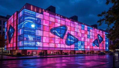 Vibrant experimental building, neon-lit facade, bold color blocking, abstract geometries, futuristic materials, iridescent glass panels, metallic accents, electric blue undertones, hot pink highlights