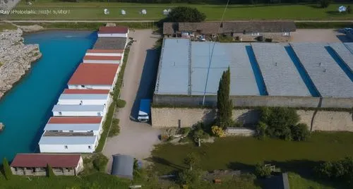 an aerial po of a factory with a large body of water,dji agriculture,fish farm,salt farm,majdanek,aquaculture,ehatchery,Photography,General,Realistic