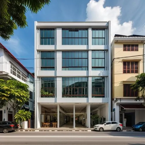 A hyper realistic image of a modern, sustainable, geometrical aligned and functional small building in the heart of Penang, Malaysia, with ample natural light. The building should be located in a bust