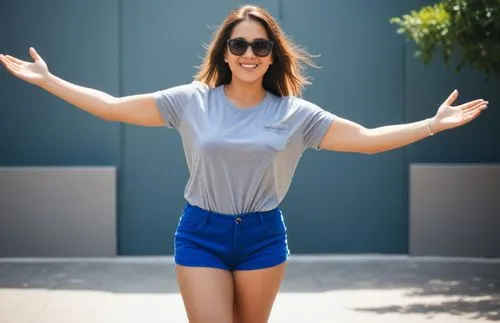 a woman with her arms wide spread in the air,nicodemou,in shorts,jean shorts,shorts,sonnleitner,saana