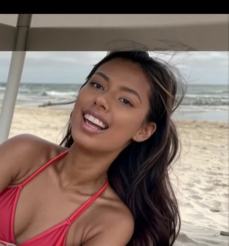 She is sunbathing on the beach.  wearing a colorful swimsuit.  She is lying on the beach and laughing.,amerie,taraji,pinay,marshallese,filipina,paulini,naomie,filipino,bonang,beach background,guelague