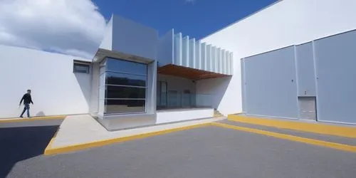 a man walking in a street between two large buildings,metaldyne,hynix,phototherapeutics,cladding,cubic house,cube house,Photography,General,Realistic