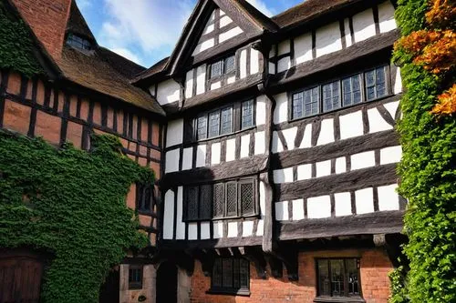 Tudor-style building, architectural design, Burton upon Trent, Staffordshire, England, UK, medieval-inspired, half-timbered facade, white render walls, steeply pitched roof, multiple chimneys, lead-pa