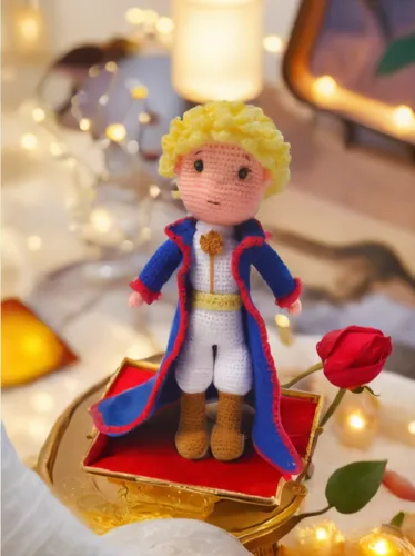 small, knitted doll of an actor with white and blue outfit standing in a red velvet box,angel gingerbread,enjolras,thorfinnur,christmas figure,elf on a shelf,brandybuck