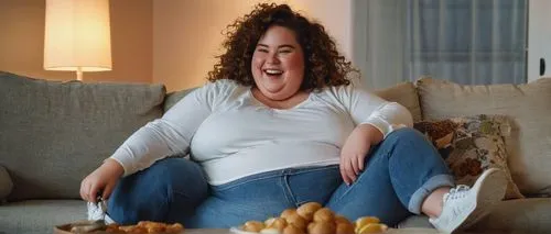 Chubby BBW, playful, laughing, belly stuffing, sweet smile, curly brown hair, minimal makeup, casual wear, loose white shirt, high-waisted jeans, sneakers, sitting on couch, snacks scattered around, T