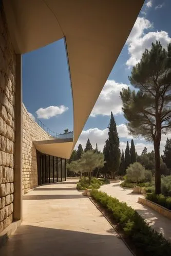 "Jerusalem Yad Vashem architecture, modern museum building, stone walls, glass roof, triangular structure, geometric shapes, memorial garden, walking path, trees with Hebrew inscriptions, Israel flag 