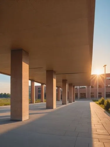 fotorgrafía de un edificio con columnas centrales y volados. materiales de concreto y ladrillo, paisaje urbano. personas,the sun is shining brightly in a large building,njitap,jadwin,iupui,ucd,umbc,ua