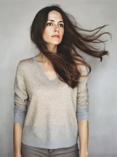 a woman with long, wavy brown hair,a woman wearing a tan sweater and grey pants,bareilles,andreasberg,lafourcade,haselrieder,bellisario,dennings,Photography,Documentary Photography,Documentary Photogr