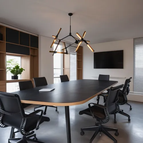 meeting room with white stucco walls and microcement flooring, with a table with a black lacquered top and dark wooden legs in the center, eight chairs with wheels with metal structure and seat and ba