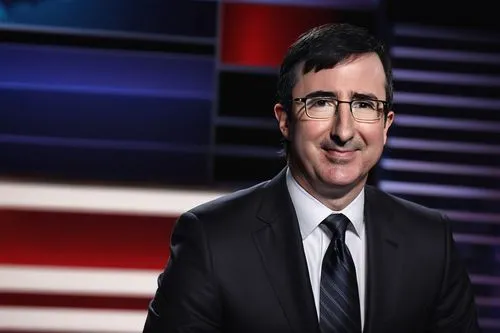 John Oliver, news anchor, middle-aged man, glasses, serious expression, white shirt, black suit, TV studio background, American flag, presidential podium, formal hairstyle, prominent nose, bright smil