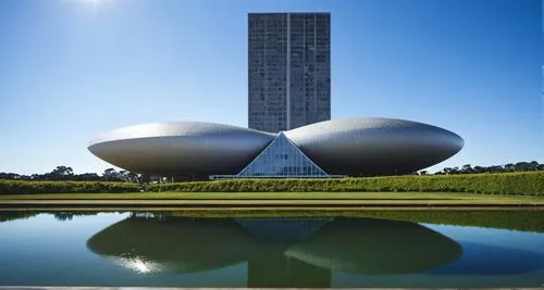 circular building looking similar to UFOshowing reflection in water at 1st level,two large domes in front of a lake,songdo,fermilab,brasilia,hengqin,zhengzhou,zhangzhou,futuroscope,wanzhou,kunshan,ord