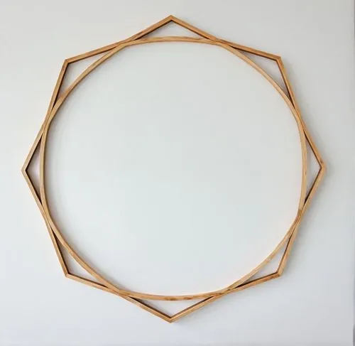 A frame made of wood against a white background,a round frame made with wooden sticks and wood strips,circle shape frame,copper frame,circular puzzle,heart shape frame,semi circle arch,bamboo frame,Co